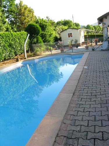 une piscine bleue avec une allée en briques dans l'établissement Le Marverand, à Saint-Julien