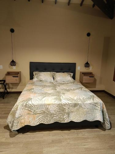 a bedroom with a large bed with two night stands at Finca MonteSer in Jardin