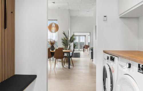 a kitchen and dining room with a washing machine and a table at Awesome Home In Odder With Sauna in Odder