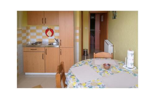 a kitchen with a table and a kitchen with a sink at 1 Bedroom Beautiful Apartment In Vrbnik in Vrbnik