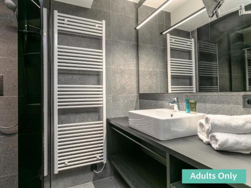 a bathroom with a sink and a mirror at Adult Only Superior Suite in Niederhof