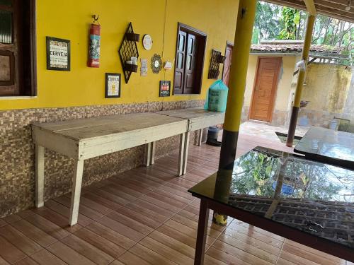 a wooden table in a room with a yellow wall at Chácara em Benevides in Benevides