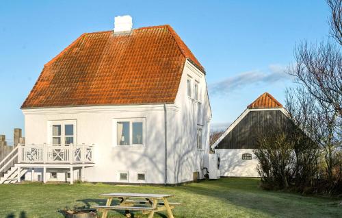 a white house with an orange roof and a picnic table at 3 Bedroom Pet Friendly Home In Ribe in Ribe