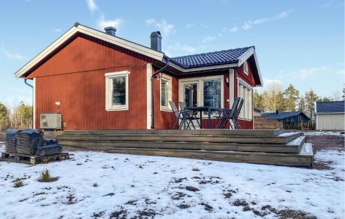 a small red house with a deck in the snow at 2 Bedroom Stunning Home In Mönsterås in Mönsterås
