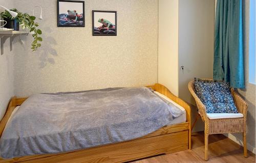 a bedroom with a bed and a chair at 2 Bedroom Stunning Home In Mönsterås in Mönsterås