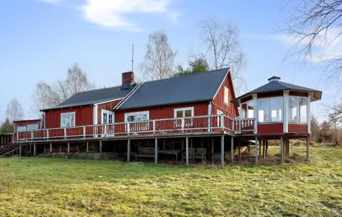 ein großes rotes Haus mit schwarzem Dach in der Unterkunft Gorgeous Home In Vittsjö With Wifi in Vittsjö