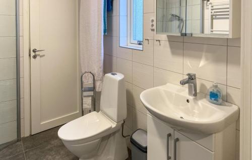 a white bathroom with a toilet and a sink at 2 Bedroom Stunning Home In Mönsterås in Mönsterås