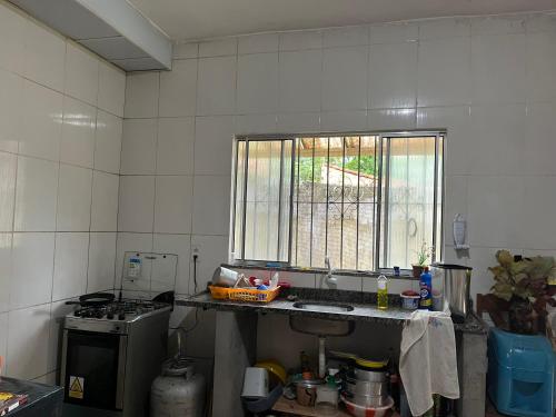a kitchen with a sink and a window at Chácara em Benevides in Benevides