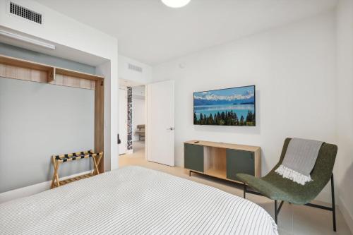 a bedroom with a bed and a chair at Stunning Lux 2 Bed 2 Bath with Panoramic View from Balcony in Miami