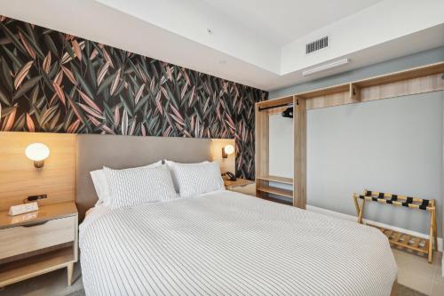 a bedroom with a bed and a floral accent wall at Stunning Lux 2 Bed 2 Bath with Panoramic View from Balcony in Miami