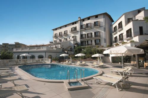 einem Pool mit Stühlen und Sonnenschirmen vor einem Gebäude in der Unterkunft Hotel Jaccarino in SantʼAgata sui Due Golfi