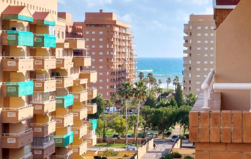 a view of a building with blue balconies and the ocean at Amazing Apartment In Oropesa Del Mar in Oropesa del Mar