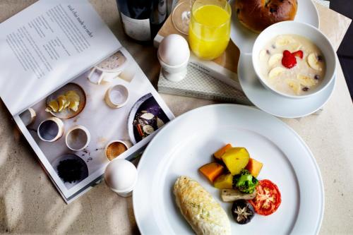 a table with two plates of food and a book at Eslite Hotel in Taipei