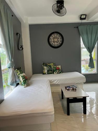 a room with two beds and a clock on the wall at Dajon#4-Barkada Generator & starlink in General Luna