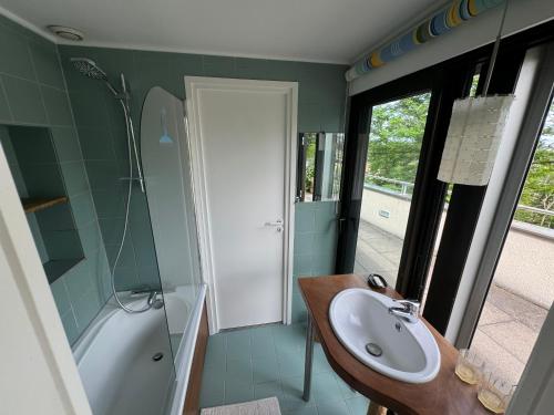 une salle de bain avec un lavabo et une baignoire dans l'établissement Havre de paix avec piscine et vue imprenable, à Durtol