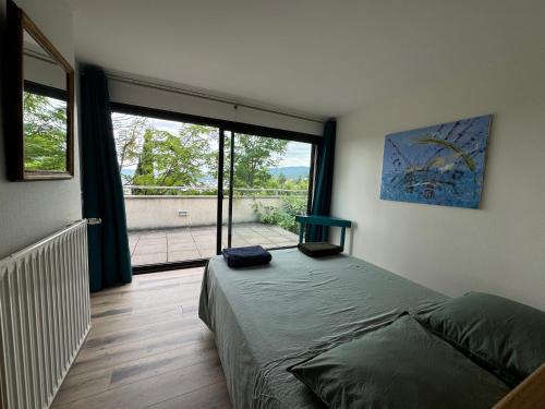 une chambre avec un lit et une grande fenêtre dans l'établissement Havre de paix avec piscine et vue imprenable, à Durtol