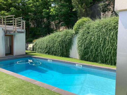 - une piscine dans une cour avec pelouse et buissons dans l'établissement Havre de paix avec piscine et vue imprenable, à Durtol