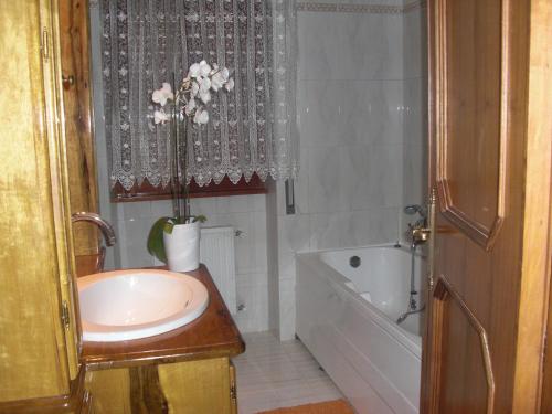 a bathroom with a sink and a bath tub and a sink at La Maison Blanche in Borghesiana 