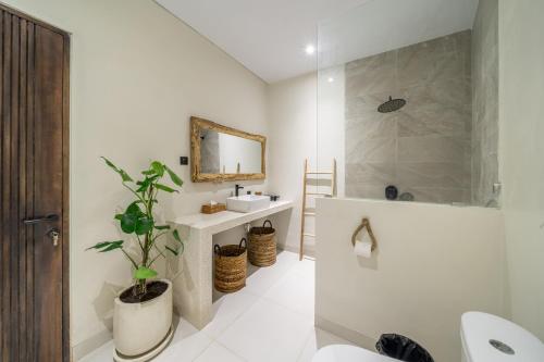 a bathroom with a sink and a toilet and a mirror at Brand New 4BDR Villa - Cozy and Stylish - CANGGU with Breathtaking Stunning View in Seminyak