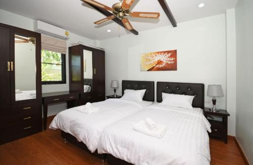 a bedroom with a large white bed with a ceiling fan at Baan Ping Tara Private Pool Villa in Ao Nang Beach