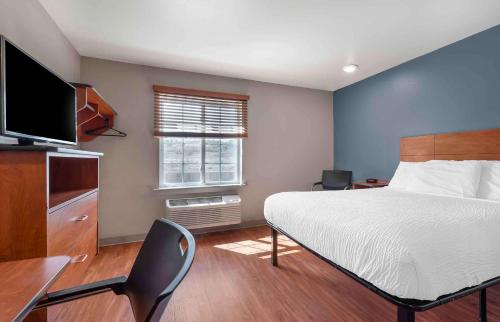 a bedroom with a bed and a desk and a television at Extended Stay America Select Suites - Colorado Springs in Colorado Springs