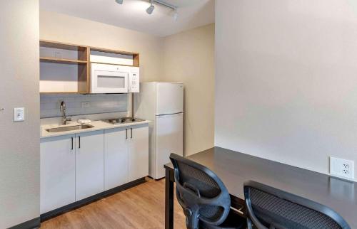 a kitchen with two chairs and a table and a refrigerator at Extended Stay America Premier Suites - San Jose - Airport in San Jose