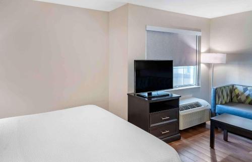 a hotel room with a bed and a tv and a chair at Extended Stay America Premier Suites - San Jose - Airport in San Jose