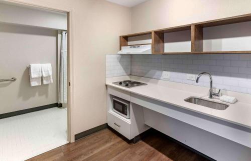 a small kitchen with a sink and a stove at Extended Stay America Premier Suites - San Jose - Airport in San Jose