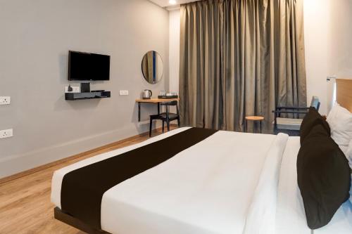 a hotel room with a bed and a television at Super Townhouse Gomti Nagar Matiyari in Lucknow