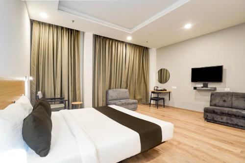 a hotel room with a bed and a flat screen tv at Super Townhouse Gomti Nagar Matiyari in Lucknow