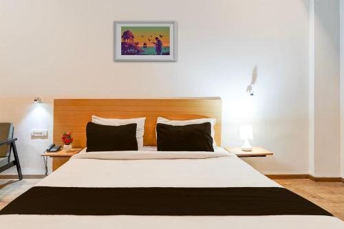 a bedroom with a large white bed with two lamps at Super Townhouse Gomti Nagar Matiyari in Lucknow
