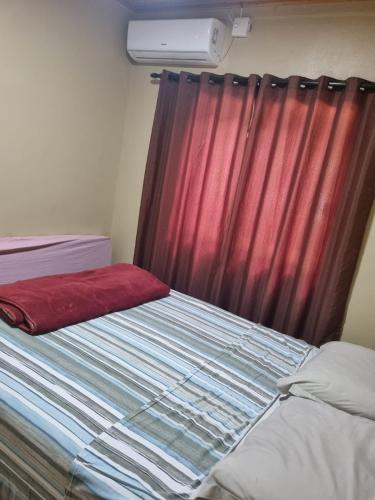 a bedroom with a bed with a red curtain at Chácara Alci Guedes in São Gabriel