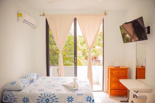 a bedroom with a bed and a large window at Hotel Palmarito in Puerto Escondido