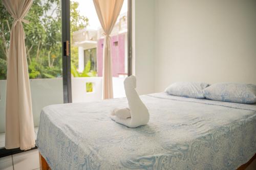 a white towel animal sitting on top of a bed at Hotel Palmarito in Puerto Escondido