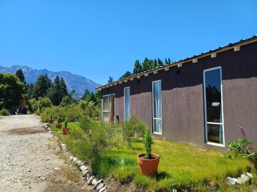 a house with plants in front of it at Entre Pueblos in Lago Puelo