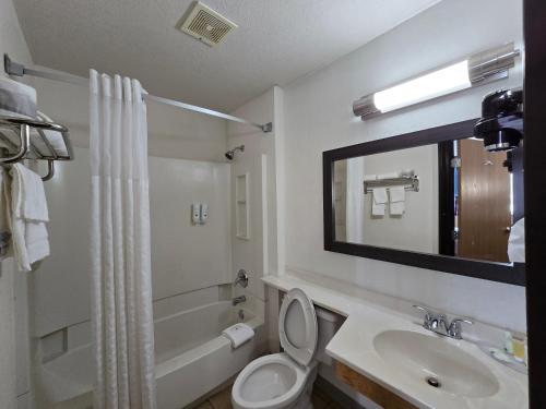 a bathroom with a toilet and a sink and a mirror at Quality Inn in Johnstown