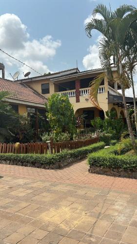 a house with a palm tree in front of it at Green house, 2bdr Apt, 7 min from Airport in Accra