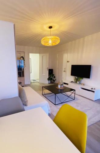 un salon avec un canapé et une télévision dans l'établissement Studio lumineux proche de Paris, à Asnières-sur-Seine