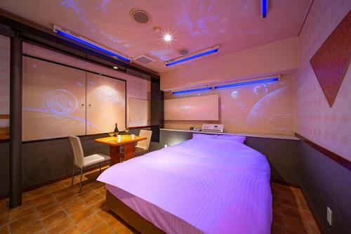 a room with a large bed and a table with a chair at 恋からSweets in Okayama