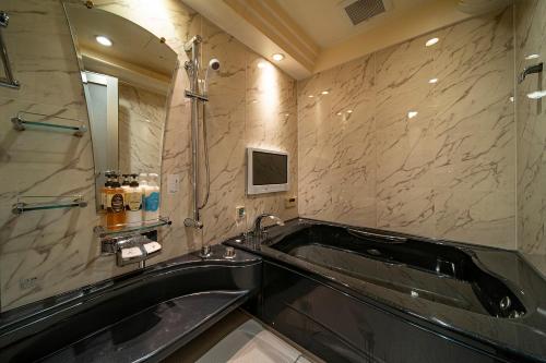 a bathroom with a tub and a sink and a mirror at 恋からSweets in Okayama