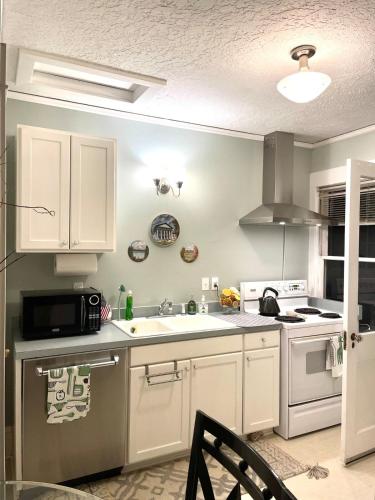 a kitchen with white cabinets and a sink at Cozy Portland Retreat in the Heart of Hollywood in Portland