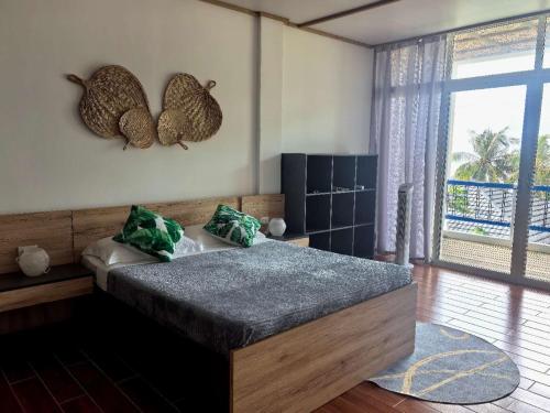 a bedroom with a bed and a large window at Blue Joys MSR in Siquijor