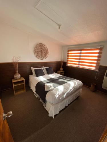 a bedroom with a large bed and a window at Hostal Amerindia in Puerto Natales
