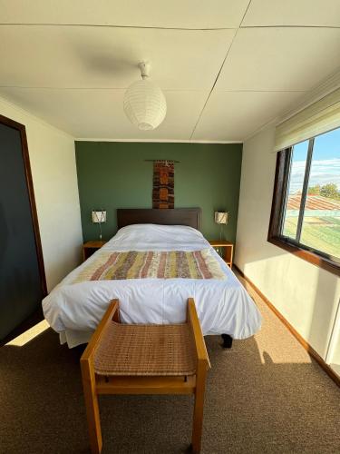 a bedroom with a large bed and a window at Hostal Amerindia in Puerto Natales