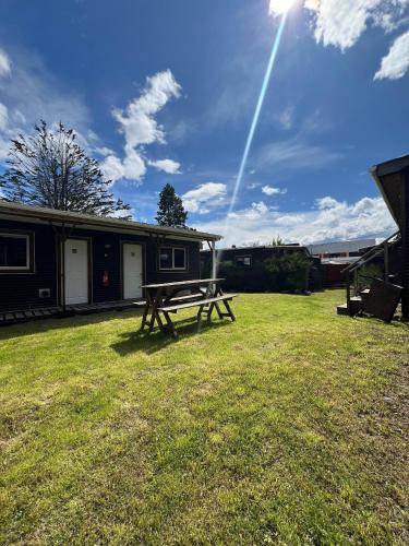 a picnic table in the grass in front of a house at Hostal Amerindia in Puerto Natales