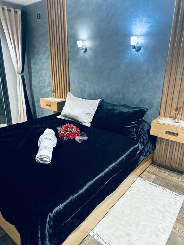 a room with a bed with a black bedspread at Fabuleux appartement vue sur mer Fibre IPTV Netflix in Mehdiya-Plage