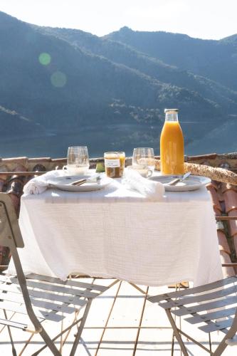 een tafel met glazen en een fles sinaasappelsap erop bij Relais - U Machjonu in Tolla