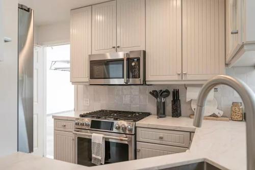 a kitchen with a stove and a microwave at Montecito-Chic Beachside Retreat in Montecito