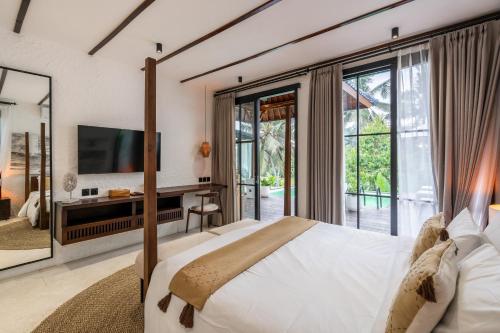 a bedroom with a large bed and a tv at Exclusive New Villa in Ubud - 2BDR, Massive Pool - Ultimate Luxury in Ubud