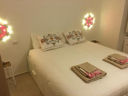 a bedroom with a white bed with towels on it at Zia Checchina in Molfetta